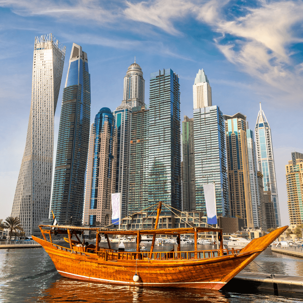 A boat in the water in front of a large city