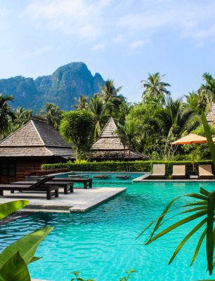 a resort with a pool surrounded by palm trees